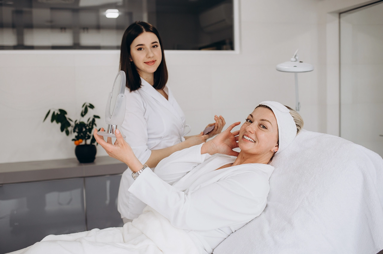 سيدة تبتسم أثناء جلسة تجميل في عيادة تجميل حديثة في الشارقة